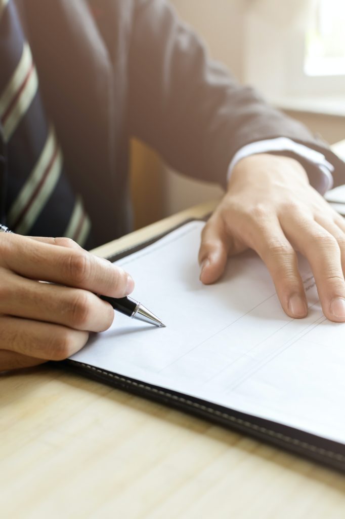 Human Hand Signing on Formal Paper at the workplace